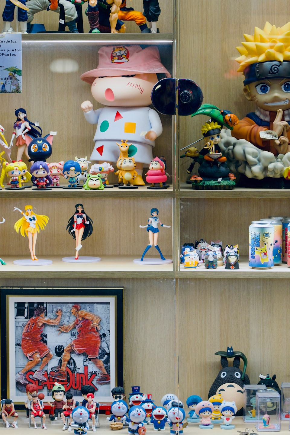 Anime and manga figurines displayed on shelves in a glass case.