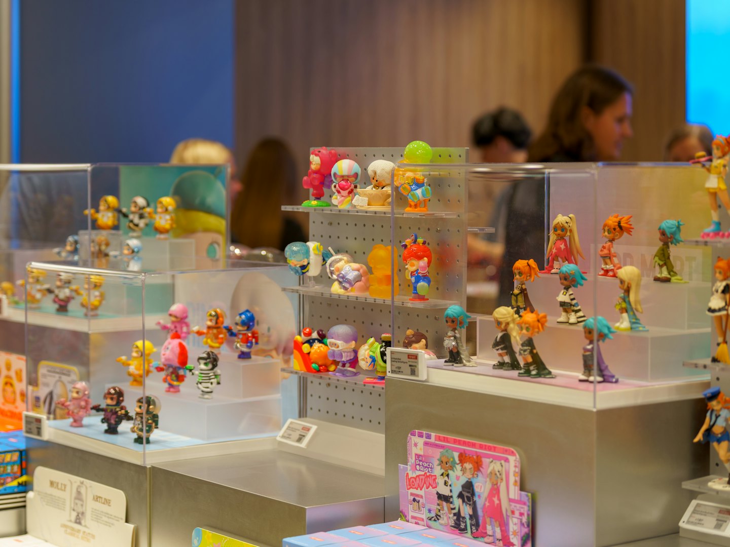 Small anime figurines arranged on tiered platforms inside display cases.